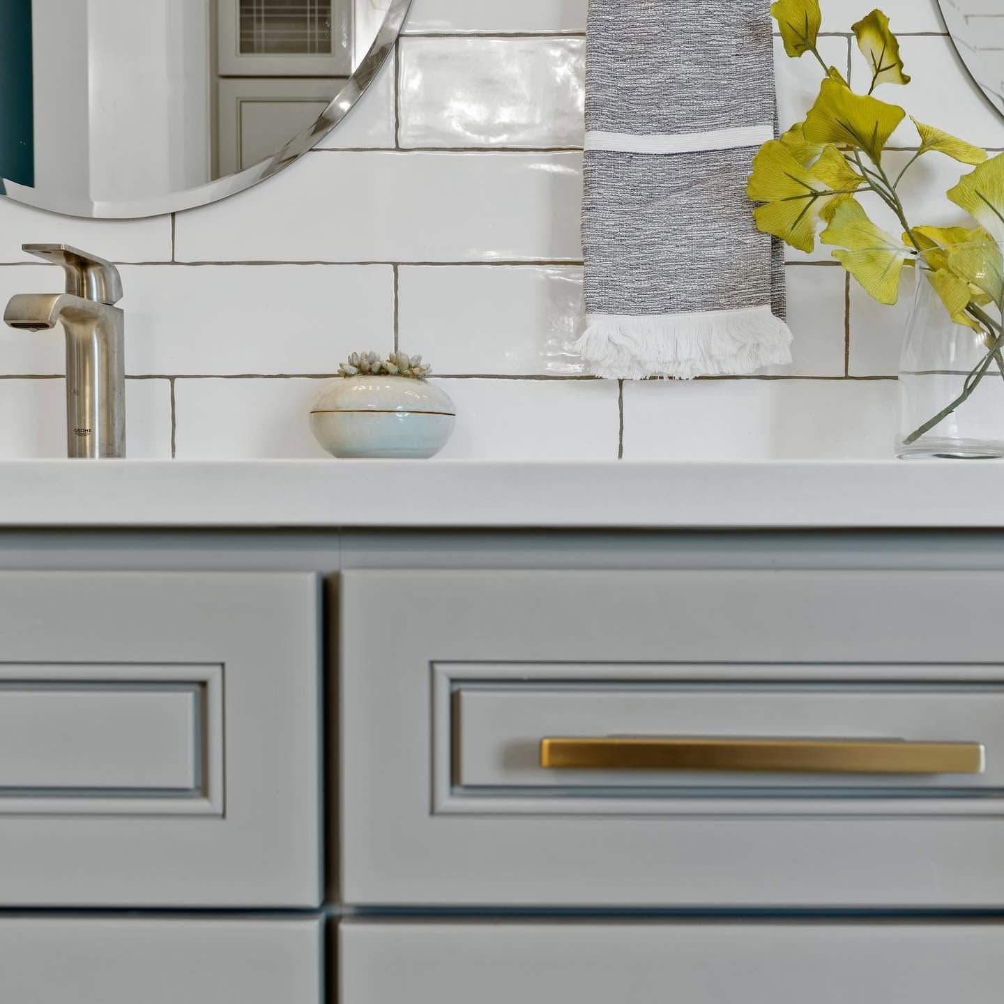 Close-up of a grey vanity drawer with a brass pull