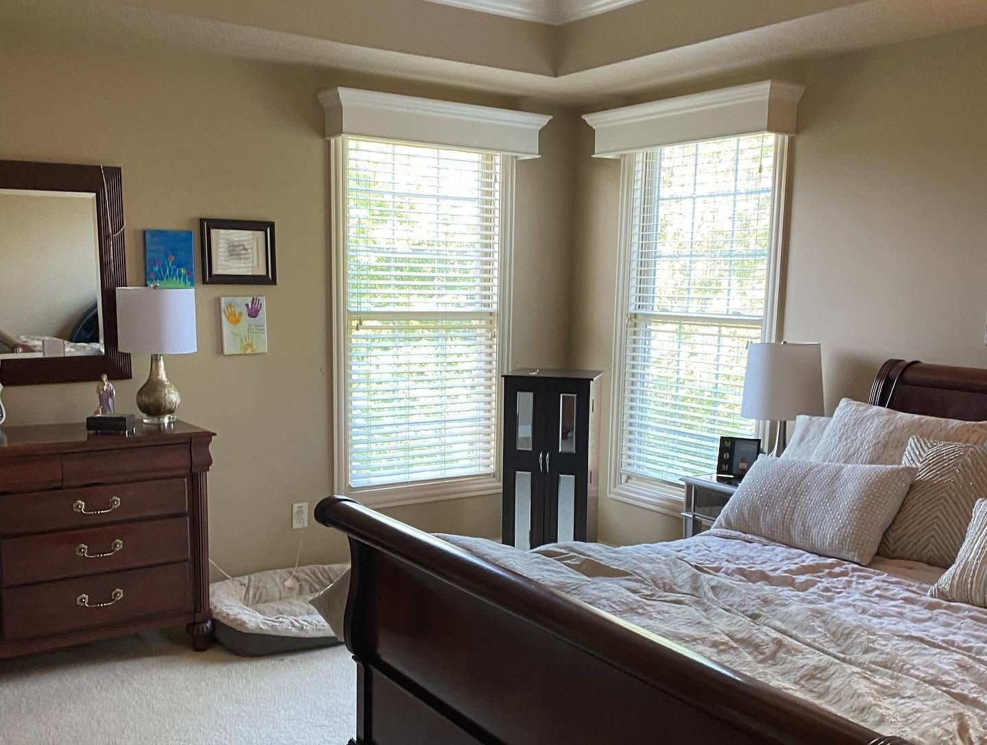 The bedroom before: beige walls, dark sleigh bed and a crowded dresser